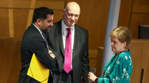 Getty Image Hues Yusuf, John Swine and Nicola Sturgeon in Holiroad