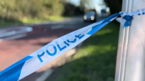 BBC/Oliver Whitfield-Miocic A close up shot of police tape on the A21