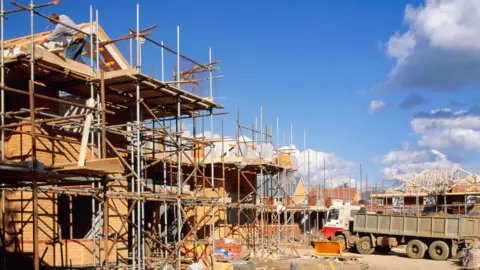 Construction site, workers building four-bedroom houses, England - stock photo