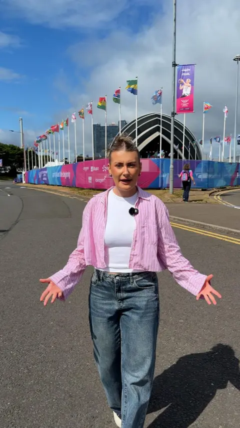 Woman in jeans and pink shirt with white vest underneath