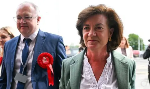 First Minister and Welsh Labour leader Eluned Morgan arrives for the count, at a school in Llandysul, Carmathenshire. Dressed in a white blouse and green jacket.