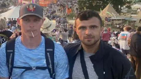 A photo released to the jury of the two accused at Glastonbury, standing together with throngs of festivalgoers in the background