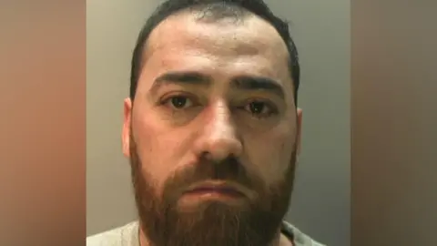 A man in a police mug shot. 