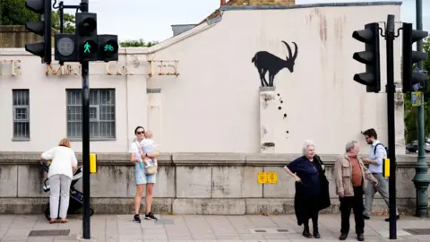 Banksy's Piranhas artwork to feature in the new London Museum 5 PA Media People walk past a depiction of a defecating goat which has been spray painted on the wall of a house in London.