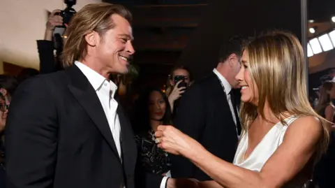 Getty image in smart clothes, Brad Pitt laughs with Jennifer Aniston