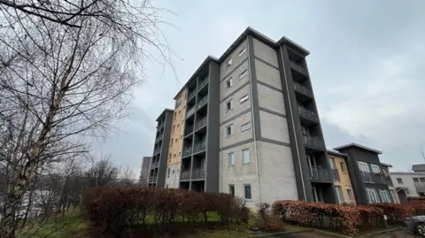 The Stephenson building at Staiths South Bank. It is a multi-storey brick building. The flats have balconies overlooking the surrounding area.