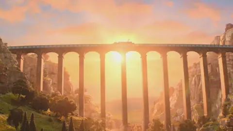 Aardman Animations An animated arched aqueduct spanning a wooded valley with steep rocky sides. There is a barge on the canal just visible and the scene is bathed in the orange pink light of a sunset. 