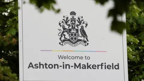 PA Media Welcome sign to Ashton-in-Makerfield with trees in the background.