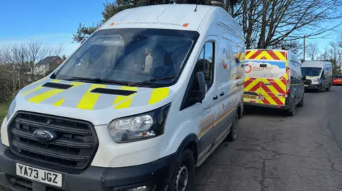 Two Wales and West Utilities vans parked on the side of a road.