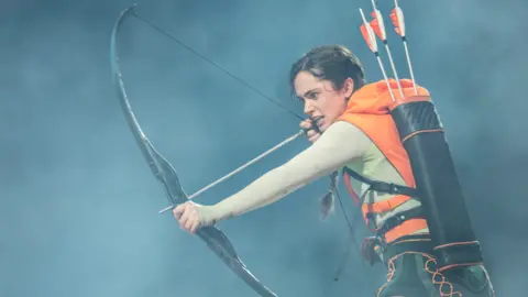 Johan Peson Mia Carnagher as Katniss wields a bow and arrow 