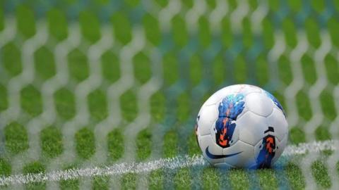 A close up of a football in a net