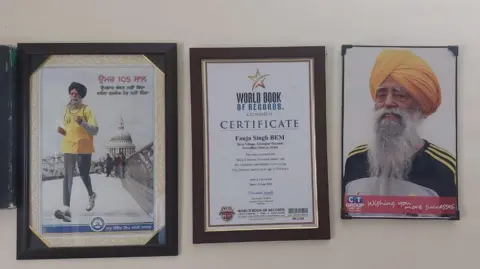 Pardeep Sharma/BBC A wall with Singh's certificates and photos.
