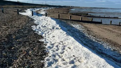 Treacs Sea foam washed up on the beach. 