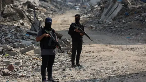 Hamas fighters guard an area of Gaza City where they are searching for the bodies of hostages with the help of the International Committee of the Red Cross (ICRC), in northern Gaza (3 November 2025)