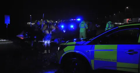 Stranraer RNLI A dark picture of police cars, lifeboat crews and flashing blue lights