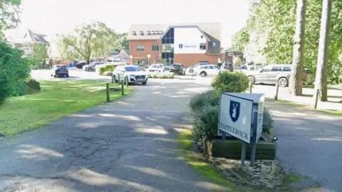 Google A Google map screen grab of a school's entrance seen from the road. A white sign says Papplewick. A carpark beyond is busy with cars. A large three-storey building with Papplewick written on white render is in the background.
