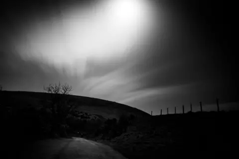 Tom Wraith Moonlight over a barren landscape