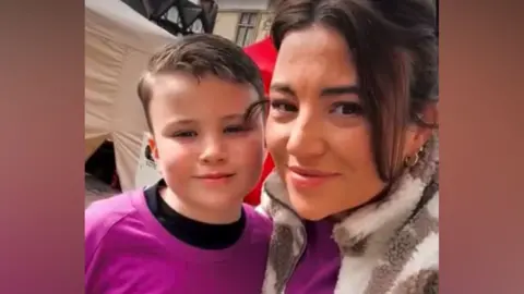 Kidney Research UK A selfie of Caelan and Sammy, who are wearing purple T-shirts and are smiling at the camera. Caelan has short dark hair while his mother has long dark hair.