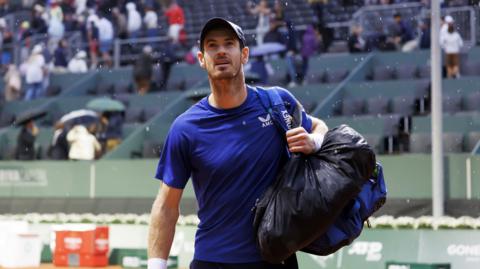 Andy Murray leaves the court as rain falls