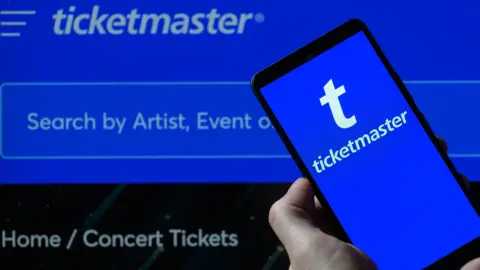 The Ticketmaster logo is being displayed on a smartphone with the Ticketmaster web home page visible in the background, in this photo illustration in Brussels, Belgium, on June 2, 2024.