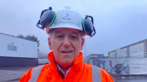 Works council chairman Michael Vernall wears orange hi-vis clothing and a safety helmet 