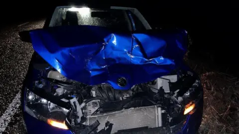 Jacquie Aitken A blue car with a crumpled front end following a collision with a deer.