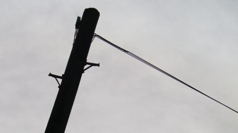 A single telegraph pole with a cable attached to the top