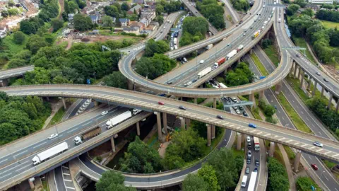 A junction involving several large, looping and straight roads that are on different levels, with some higher up than others.