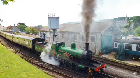 Steam train with smoke pouring from funnel in Swange