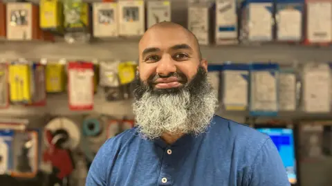 Steve Jones/BBC Abdul Ghafoor, an Asian man with a black and grey beard. He is smiling in the photo and wearing a blue t-shirt.