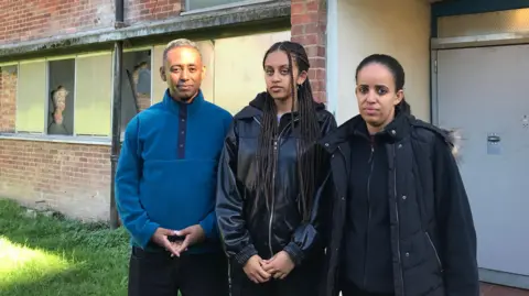 BBC The Woldehiwot family outside their home on the South Acton estate