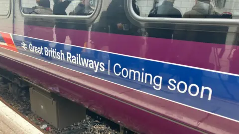 A large sign on the side of a purple railway carriage, which reads Great British Railways coming soon