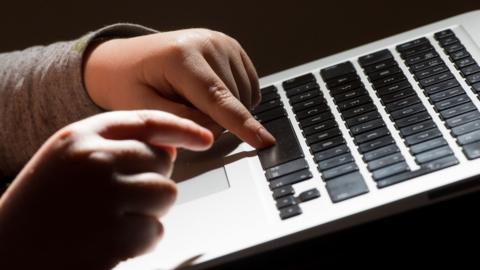 A child's hands on a keyboard.