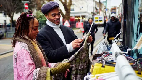 Shoppers look at clothes outside at a shop on a street in the UK