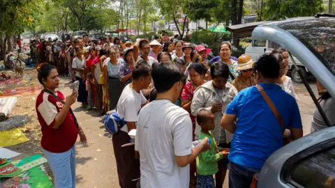 Reuters People queue for donated relief supplies following the earthquake in Mandalay, Myanmar.