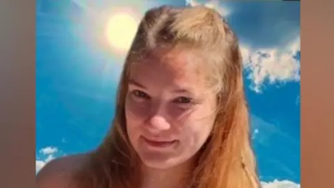 Nottinghamshire Police Orinata Narbutaite is pictured. She has long light brown hair. She is wearing a summer dress patterned with flowers.