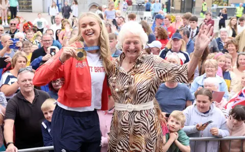 Pacemaker Hannah Scott wearing red jacket and white t-shirt with Mary Peters