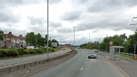 Google Image shows a dual carriageway, with houses on the left handside and cars travelling down the right hand side