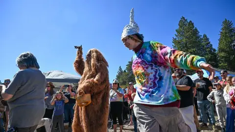 Anjali Sharif-Paul, The Sun/SCNG via Getty Images Collin Ware dances around Bigfoot during the first annual Bigfoot Festival, hosted at the Running Springs Farmers Market on Saturday, Oct. 11, 2025.