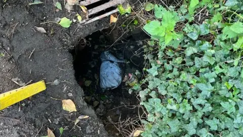 BBC The hole in the road which is a metre deep