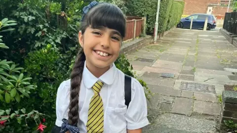 Family handout Alice Aguiar smiles at the camera. She is wearing school uniform and has her hair in a plait
