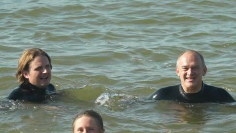 Steff Aquarone and Sir Ed Davey swimming in the sea