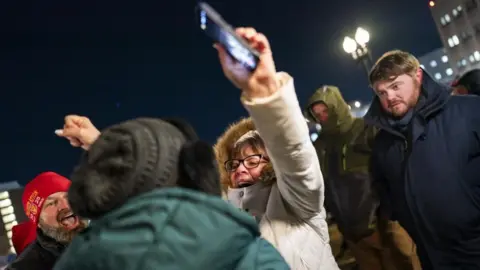 People react as they gather outside the DC Central Detention Facility, commonly known as the DC Jail, in anticipation of a potential pardon by U.S. President Donald Trump for individuals convicted in connection with the January 6, 2021