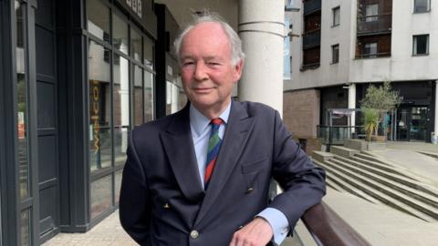 Philip Seccombe, the Police and Crime Commissioner for Warwickshire, in a suit outside a BBC building 