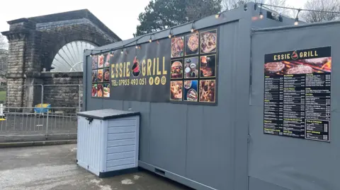 Takeaway in a shipping container in front of a large fanned window