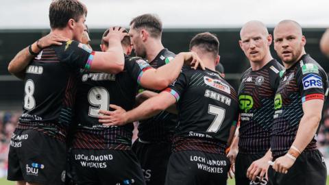 Brad O’Neill of Wigan celebrates with team-mates after scoring a try.