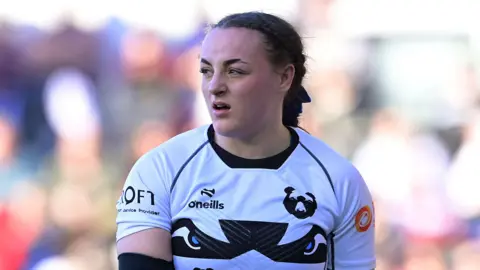 Evie Gallagher standing on the pitch looking over her right shoulder during a game for Bristol in March 2025
