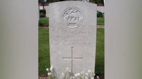 David Stuckey A stone grave in a graveyard. It shows the name of Sgt Thompson, his date of death and has a cross engraved on it