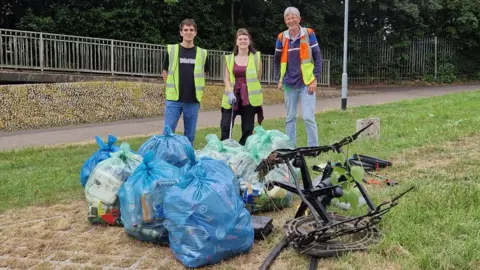 Peterborough Litter Wombles Litter picking volunteers pose in front of collected rubbish bags 