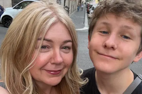 Anne Robinson A selfie photo of lady with blonde hair and her teenage son smiling at the camera during their trip to Rome.